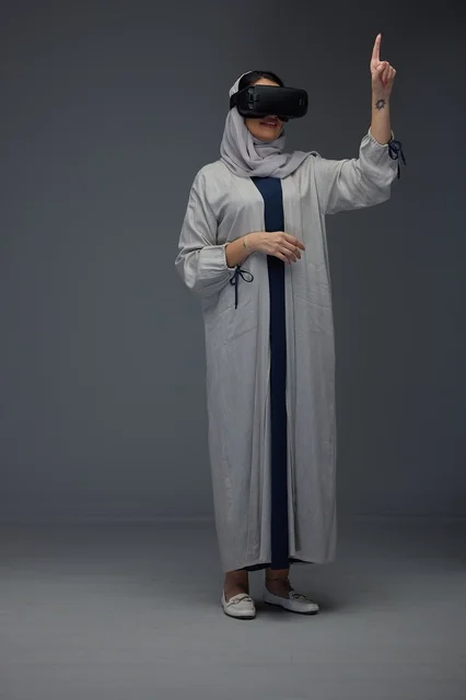 امرأة سعودية تستخدم نظارة الواقع الافتراضي بعباءة رمادية