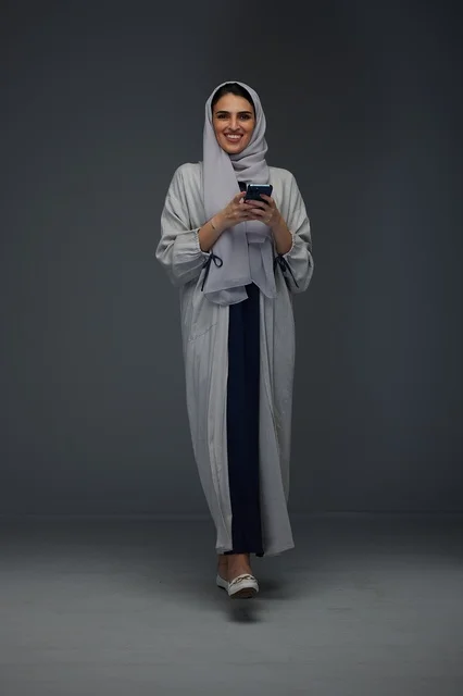 Saudi Woman with Smartphone in Grey Abaya and Hijab