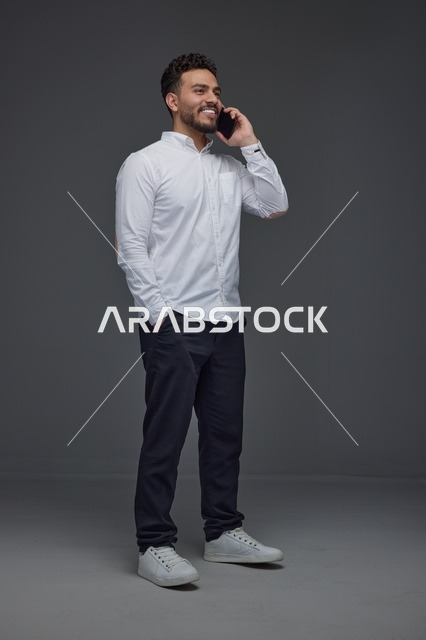 رجل سعودي يتحدث عبر الهاتف الذكي في استوديو تصوير