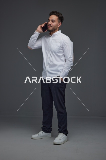 رجل سعودي يتحدث عبر الهاتف في استوديو لقطة كاملة