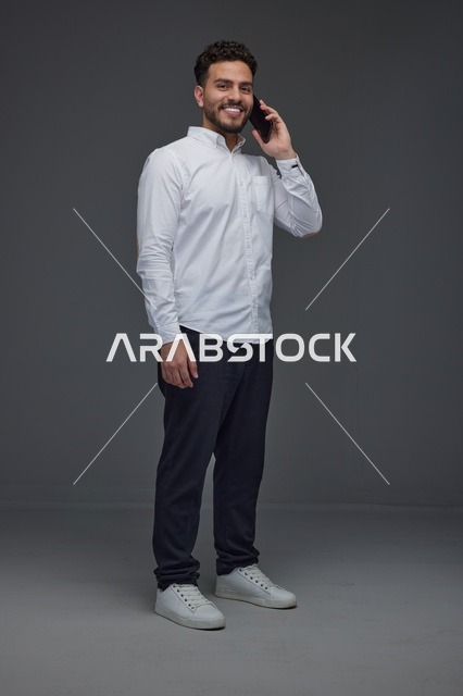 رجل سعودي يتحدث عبر الهاتف الذكي في الاستوديو