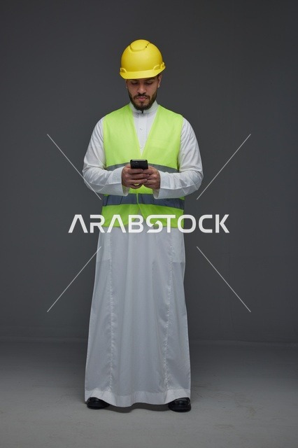 مهندس سعودي يستخدم الجوال بمعدات السلامة