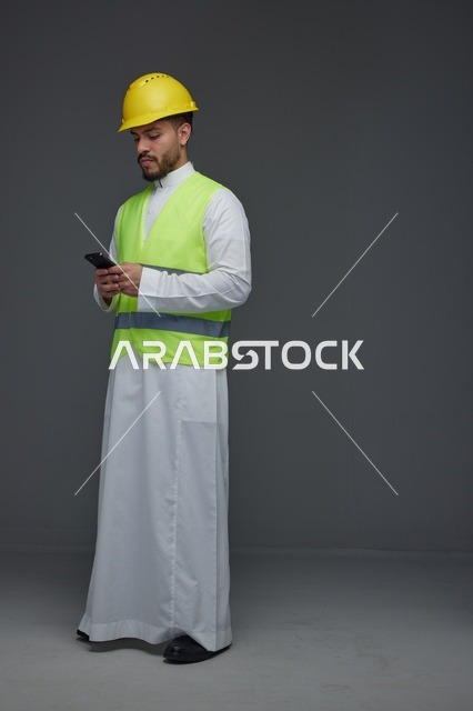 مهندس سعودي يستخدم الهاتف الذكي بمعدات السلامة