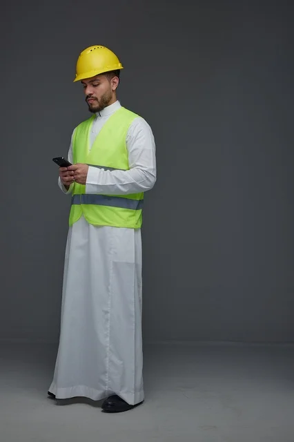 مهندس سعودي يستخدم الهاتف الذكي بمعدات السلامة