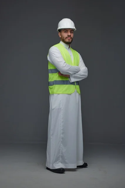 مهندس سعودي في الاستوديو يرتدي سترة السلامة وخوذة