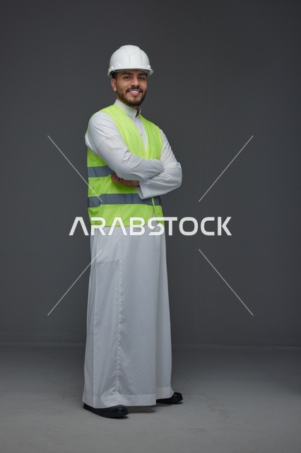 مهندس سعودي يرتدي سترة السلامة والخوذة