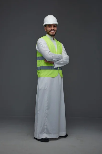 مهندس سعودي يرتدي سترة السلامة وخوذة العمل