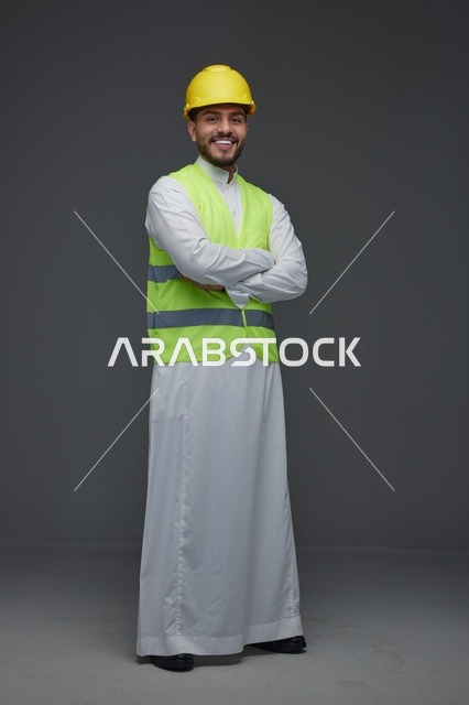 مهندس سعودي يرتدي سترة السلامة وخوذة العمل