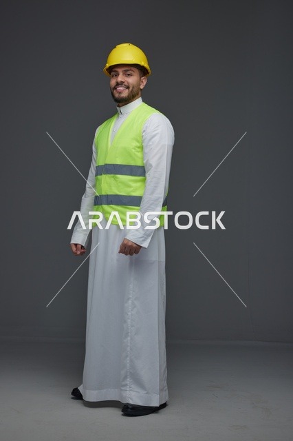 مهندس سعودي يرتدي سترة السلامة وخوذة الأمان الصفراء