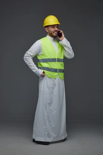 Saudi Engineer in Safety Vest Using Smartphone Studio