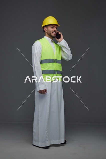 مهندس سعودي بزي السلامة يتحدث عبر الجوال