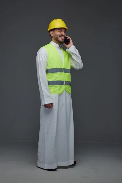 مهندس سعودي يتحدث بالهاتف بملابس السلامة