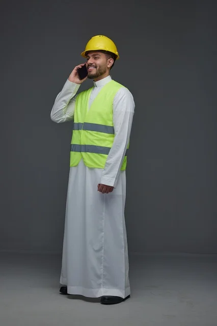 مهندس سعودي بمعدات السلامة يتحدث عبر الهاتف المحمول مهندس سعودي بمعدات السلامة يتحدث عبر الهاتف المحمول
