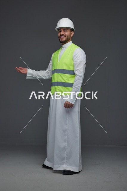 مهندس سعودي يرتدي سترة الأمان وخوذة البناء