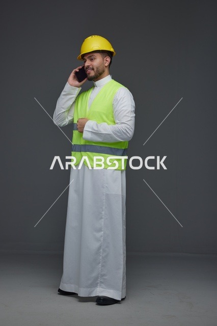مهندس سعودي بسترة أمان يتحدث عبر الهاتف المحمول