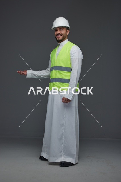 مهندس سعودي يرتدي سترة الأمان وخوذة صلبة في الاستوديو