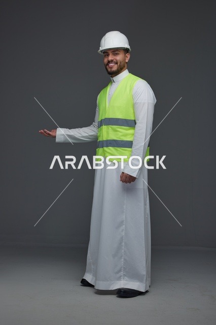 مهندس سعودي يرتدي سترة الأمان وخوذة العمل