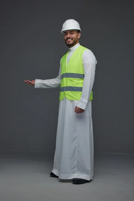 مهندس سعودي يرتدي سترة الأمان وخوذة العمل