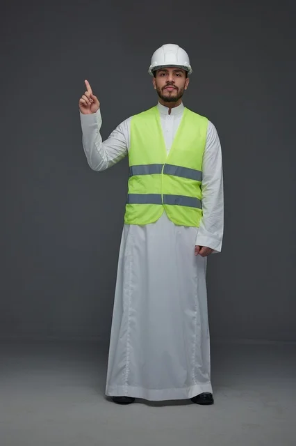 مهندس سعودي يرتدي سترة السلامة ويشير للأعلى