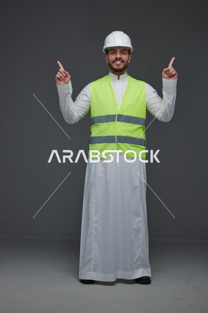 مهندس سعودي يرتدي سترة الأمان وخوذة العمل