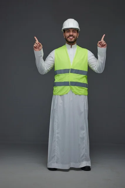 مهندس سعودي يرتدي سترة الأمان وخوذة العمل
