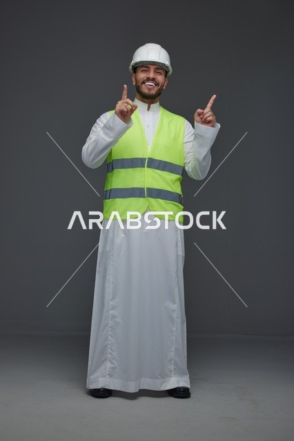 مهندس سعودي يرتدي سترة الأمان ويشير للأعلى