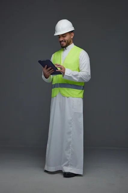 مهندس سعودي يرتدي سترة السلامة ويستخدم تابلت