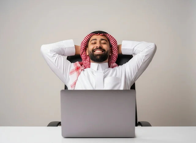 موظف سعودي يرتدي الثوب والشماغ يسترخي في مكتب العمل