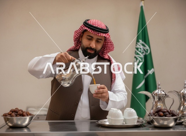 رجل سعودي يصب القهوة العربية مع العلم الوطني