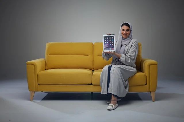 Saudi Woman on Yellow Sofa Holding Digital Tablet Studio