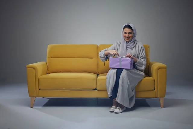 Saudi Woman on Yellow Sofa with Gift Box