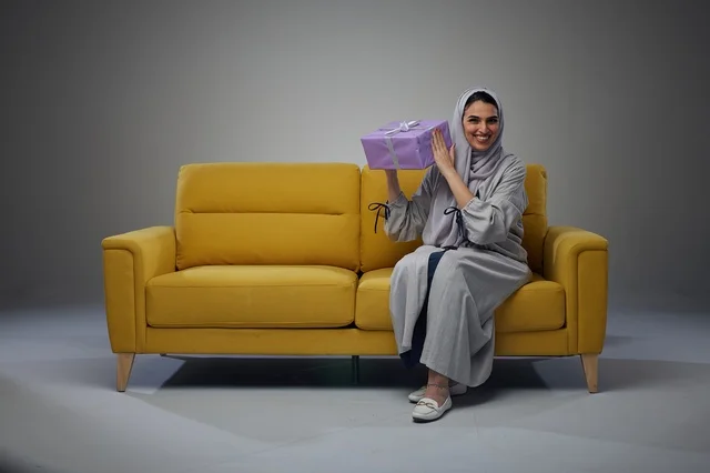Saudi Woman on Yellow Sofa with Gift Box