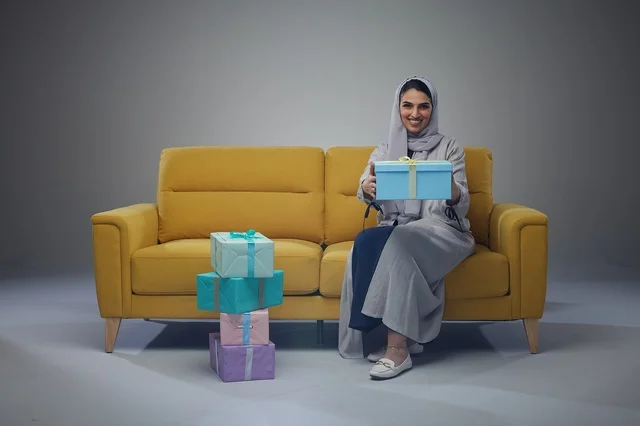 Saudi Woman with Gift Boxes on Yellow Sofa