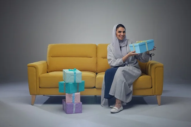 Saudi Woman with Gift Boxes on Yellow Sofa