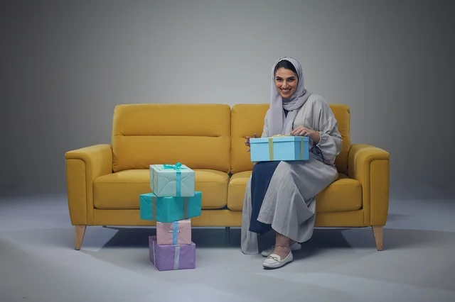 Saudi Woman on Yellow Sofa with Gift Boxes