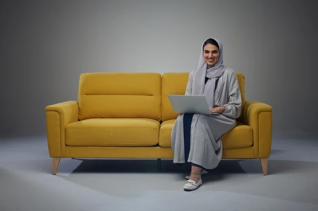 Saudi Woman with Laptop on Yellow Sofa in Studio