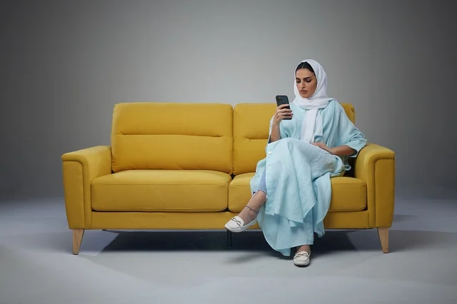 Saudi Woman Sitting on Sofa and using smartphone