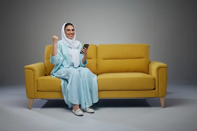 Saudi Woman on Yellow Sofa Using Smartphone Success