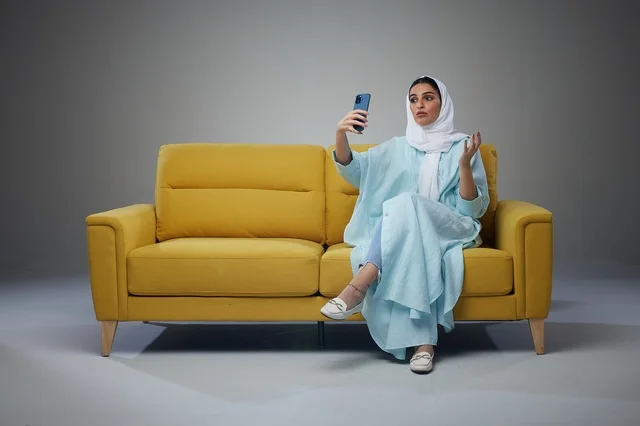 Saudi Woman Sitting on Sofa and taking a selfie