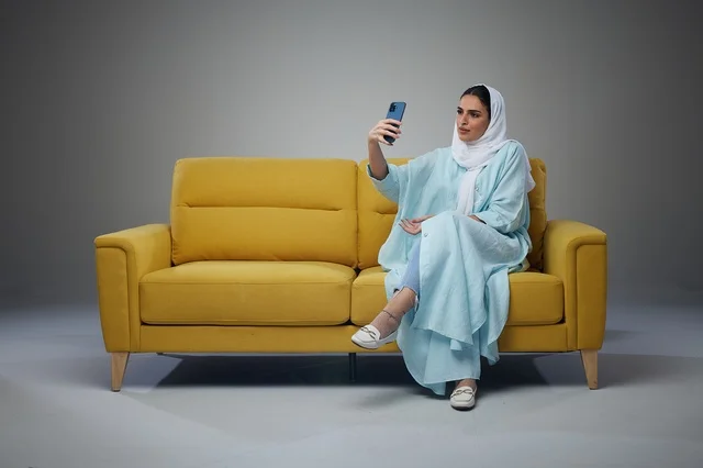 Saudi Woman Sitting on Sofa and taking a selfie
