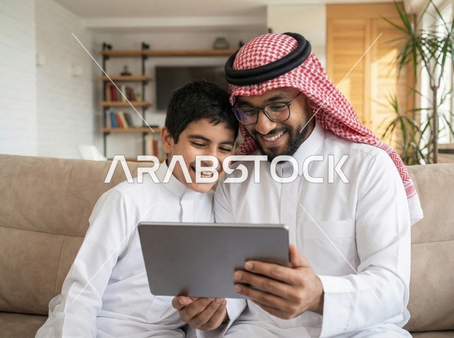 Saudi Father and Son Using Tablet in Living Room