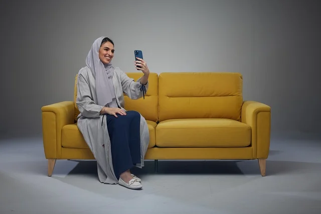 Saudi Woman Taking Selfie on Yellow Sofa