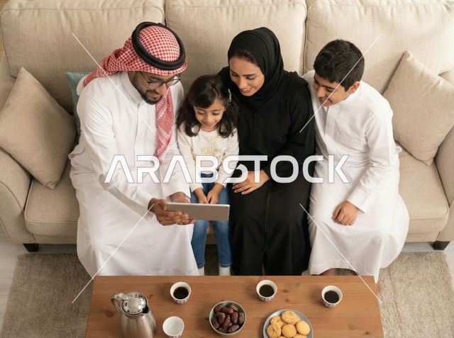 عائلة سعودية تستخدم جهاز لوحي في غرفة المعيشة