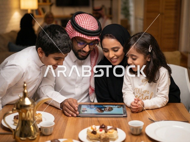 عائلة سعودية تستخدم جهاز لوحي على طاولة الطعام