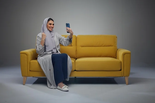 Saudi Woman Sitting on Sofa Taking Selfie
