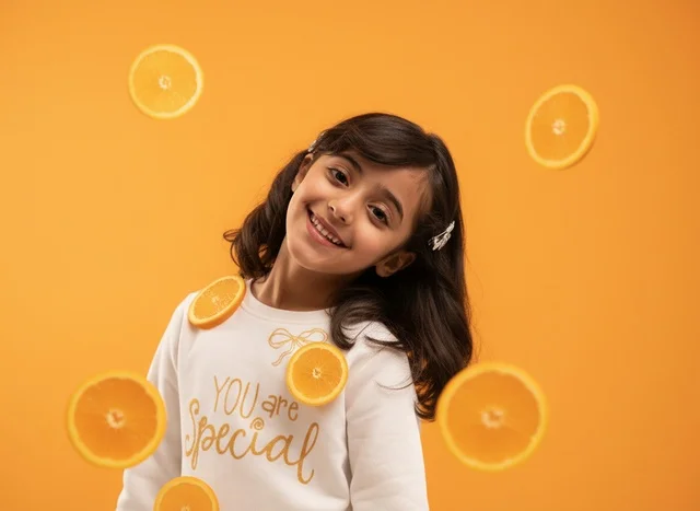Arab Girl with Floating Orange Slices on Orange Background