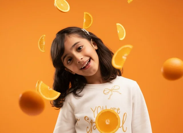 Saudi Girl with Floating Orange Fruit in Studio