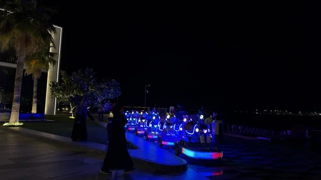 مركبات ترفيهية مضيئة على واجهة القطيف البحرية ليلاً