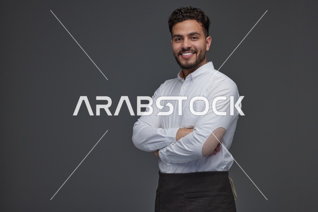 رجل سعودي مبتسم بقميص أبيض ومئزر أسود