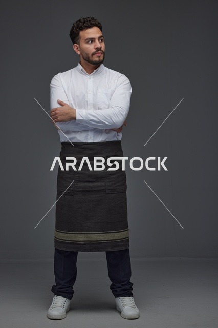 رجل سعودي يرتدي مئزر عمل احترافي في الاستوديو